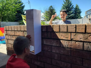 Two kids playing with a DIY periscope