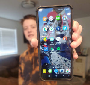 Teenager holding up a cell phone