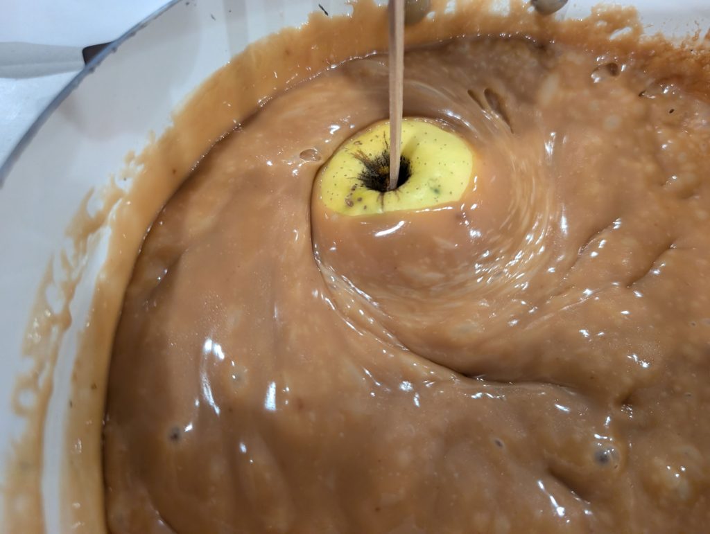 Dipping an apple in caramel sauce