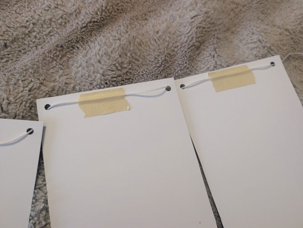 Tape the string to the back of the banner