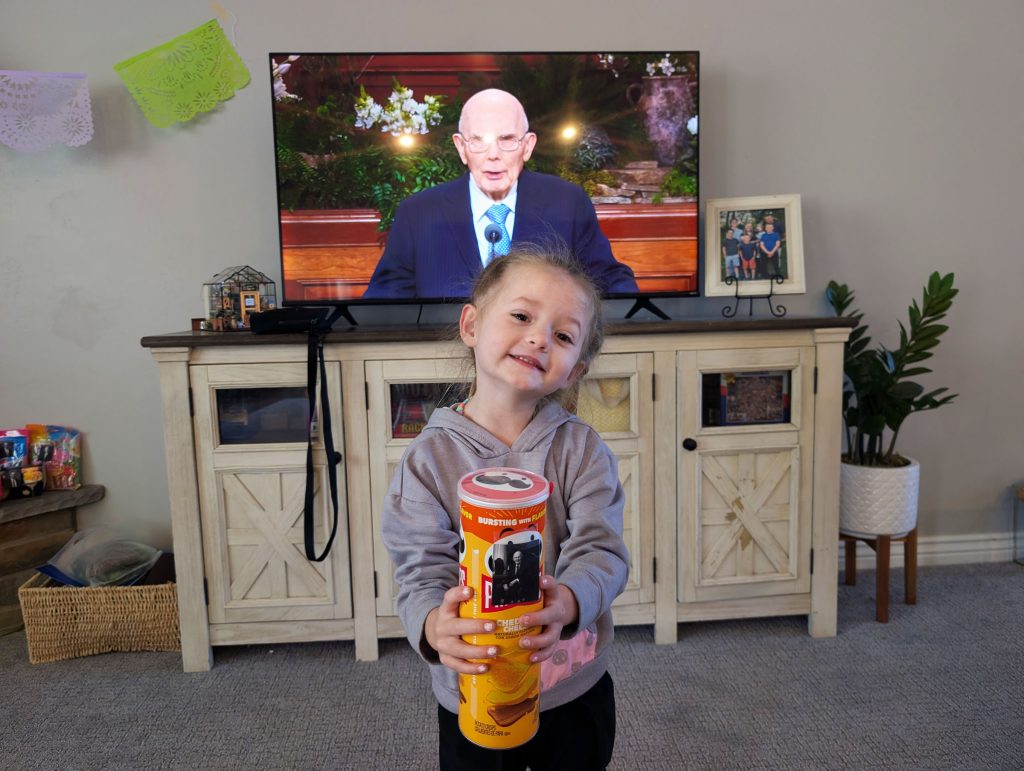My daughter holding Pringles with a picture of the prophet attached