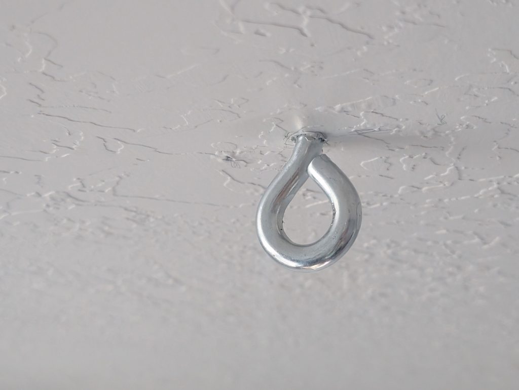 Screw the screw eye hook into a stud in the ceiling